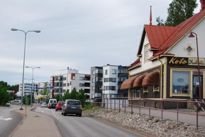 Taloja ja katu, jonka varrelle pysäköity autoja.