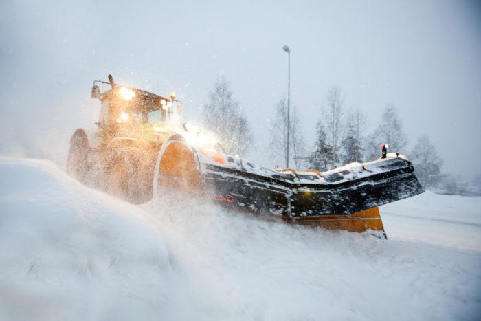 Traktori auraa lunta liikenneväylällä