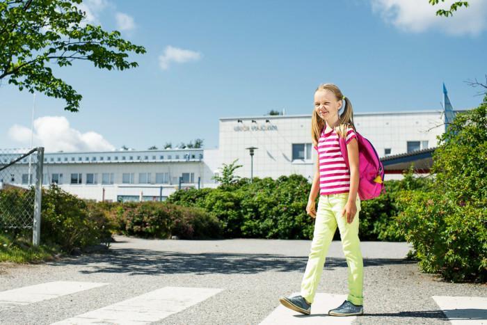 Lapsi suojatiellä koulun edustalla