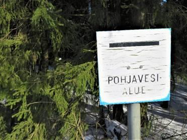 Metsässä kyltti, jossa lukee pohjavesialue.