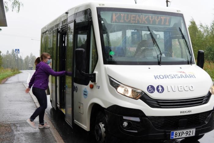 Nainen on nousemassa Kivenkyyti-bussiin.